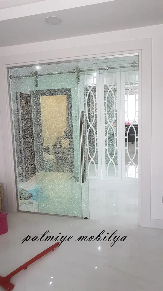 Raylı çatlak desenli cam sürgü kapının ardında dalga çıtalı beyaz vestiyer kapakları