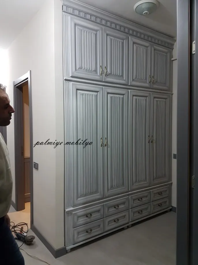 Koridora yerleşmiş gri patinalı vestiyerde dişli korniş, yivli kapaklar ve alt çekmeceler