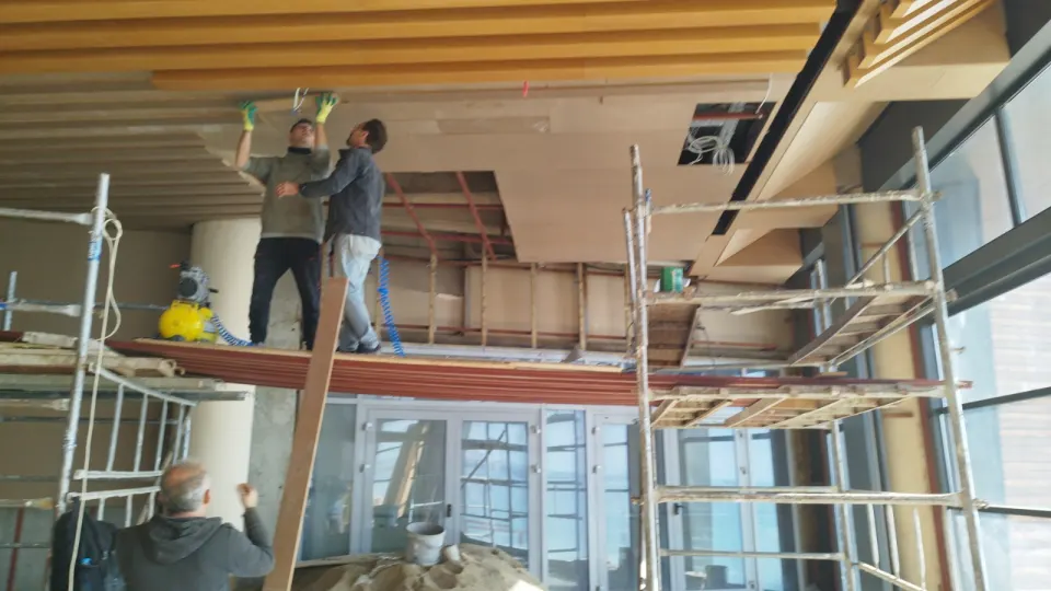 Ustaların iskele üzerinde ahşap tavan panellerini yerleştirdiği restoran dekorasyonu