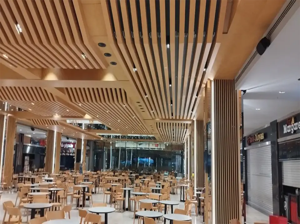 Kepenkli dükkan cepheleri yanında spot aydınlatmalı ahşap çıtalı tavan ve kolon kaplaması