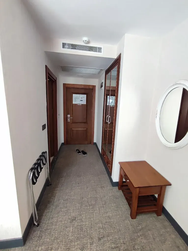 Otel Odası Giriş Holü – Aynalı Dolap ve Ahşap Bavul Sehpası