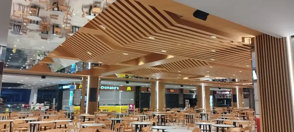 Showroom ve ofis ahşap dekorasyonuna örnek, yemek alanında katmanlı çıtalı tavan ve sütunlar
